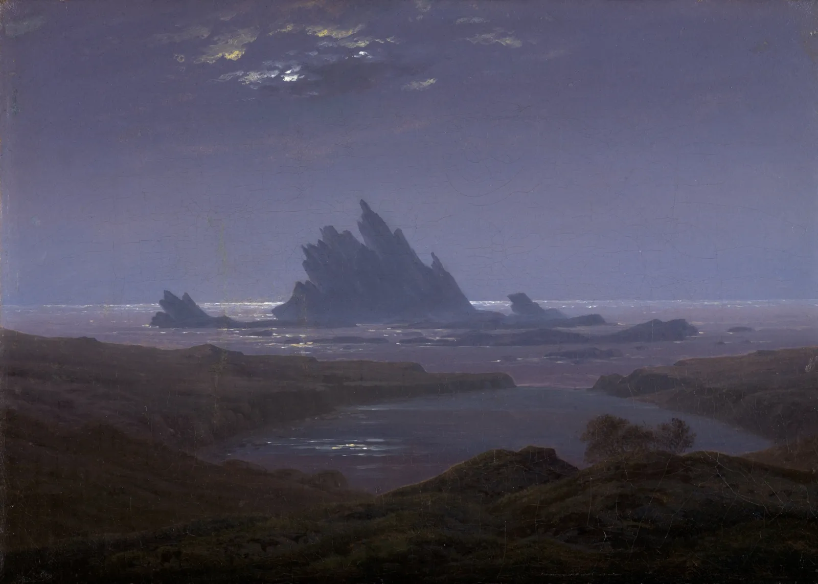 L'image est une peinture de Caspar David Friedrich. Elle représente une vue de littoral par une nuit claire, la lumière de la lune perce à tavers quelques nuages épars en partie haute de l'image. La côte forme un petit lagon au centre du tableau. Face à lui se dresse un imposant récif rocheux aux arêtes acérées.