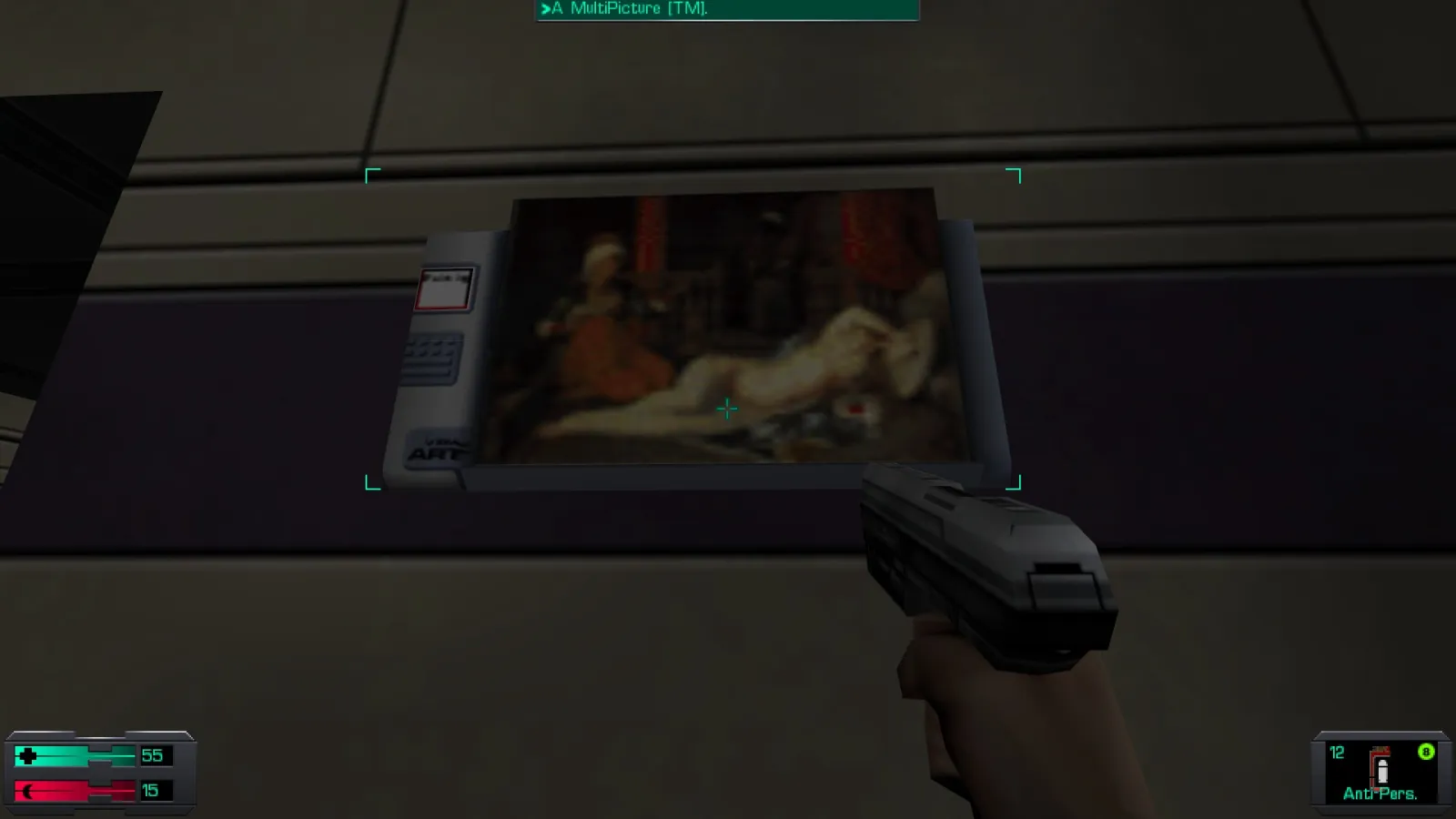 L'image est une capture d'écran du jeu System Shock 2. Le protagoniste du jeu, dont la vision se confond avec le cadre de l'image, tient un pistolet dans sa main droite, et il se tient devant un écran accroché au mur d'une des pièces d'un station spatiale. L'écran diffuse l'image du tableau "L'Odalisque à l'esclave" de Jean-Auguste-Dominique Ingres.
