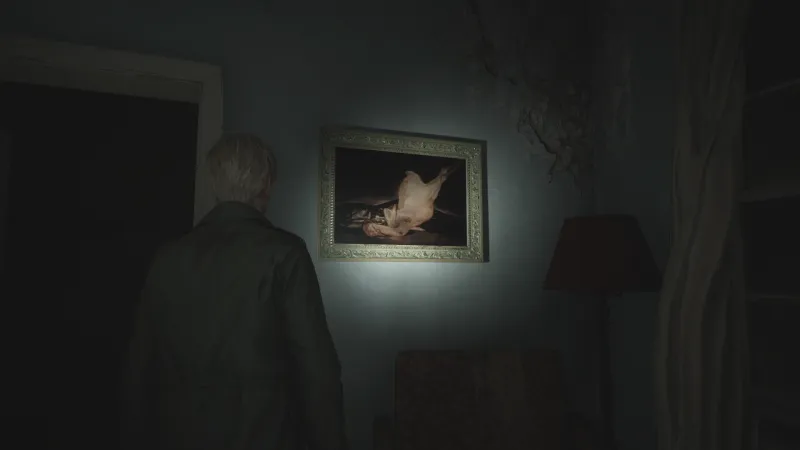 Capture d'écran de Silent Hill 2 qui montre le personnage de James Sunderland de dos. Il fait face à un mur sur lequel est accroché le tableau "La Dinde plumée" de Francisco de Goya