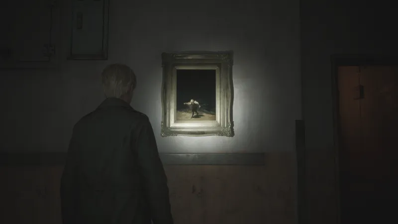 Capture d'écran de Silent Hill 2 qui montre le personnage de James Sunderland de dos. Il fait face à un mur sur lequel est accroché le tableau "Le Vol des Sorcières" de Francisco de Goya