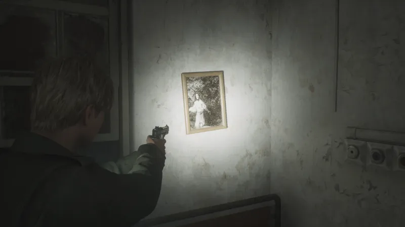 Capture d'écran de Silent Hill 2 qui montre le personnage de James Sunderland de dos. Il fait face à un mur auquel est accrochée la gravure "Tristes pressentiments de ce qui doit arriver" de Francisco de Goya