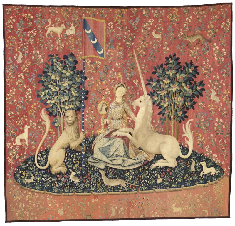L'image est une tapisserie représentant un petit espace de verger entouré d'un fond rouge fleuri. Dans ce verger se tient assise une jeune fille, accompagné d'un lion tenant un fanion, et d'une licorne dont les pattes de devant son posé sur les genoux de la jeune fille.
