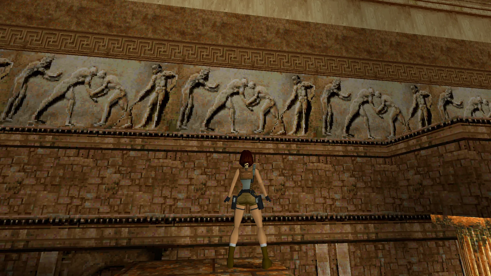 Capture d'écran de Tomb Raider dans laquelle on voit un relief grec antique représentant une scène de palestre, avec deux lutteurs en son centre