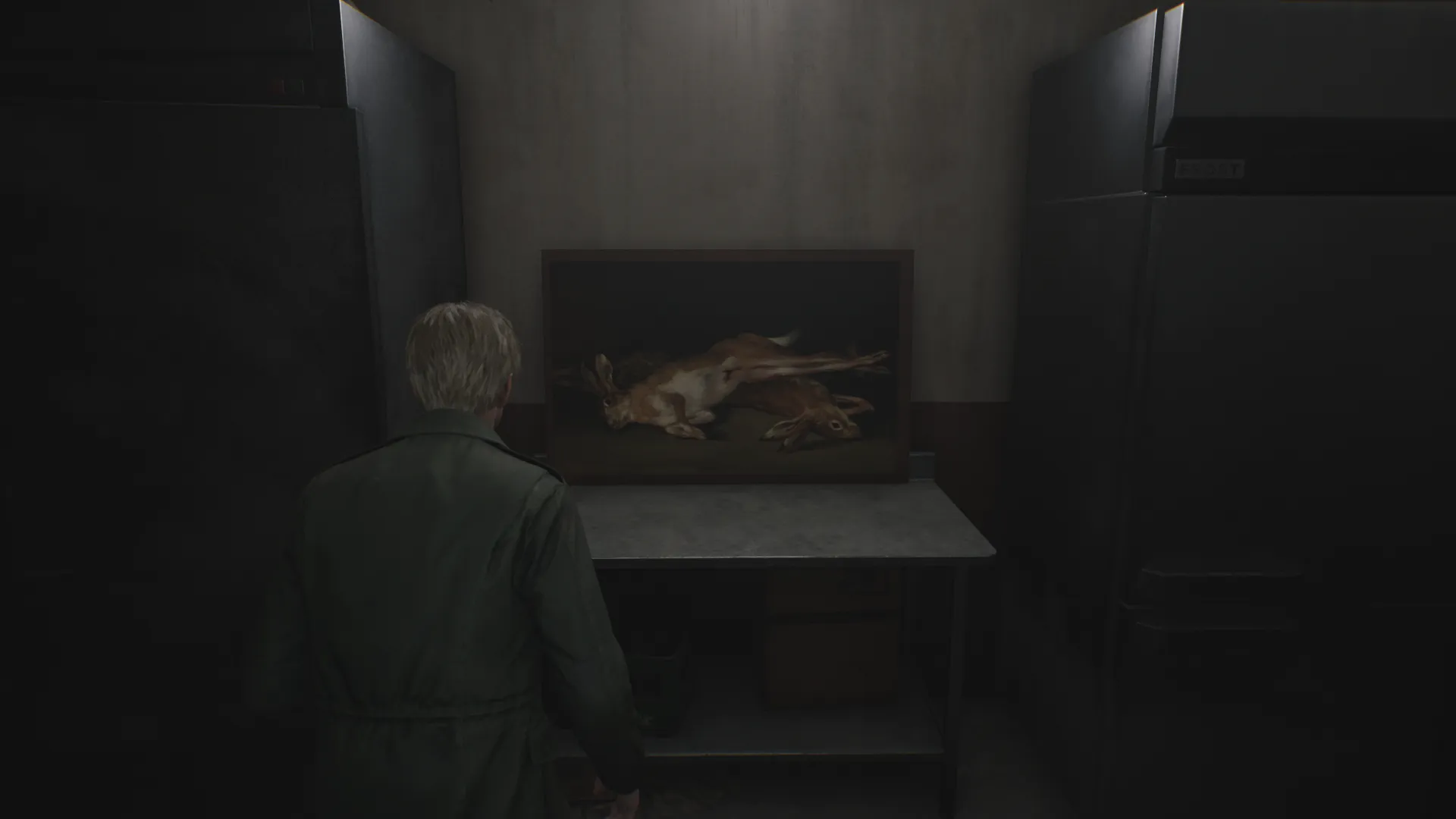 Capture d'écran de Silent Hill 2 qui montre le personnage de James Sunderland de dos. Il fait face à une table sur laquelle est posé le tableau "Nature morte aux lièvres" de Francisco de Goya