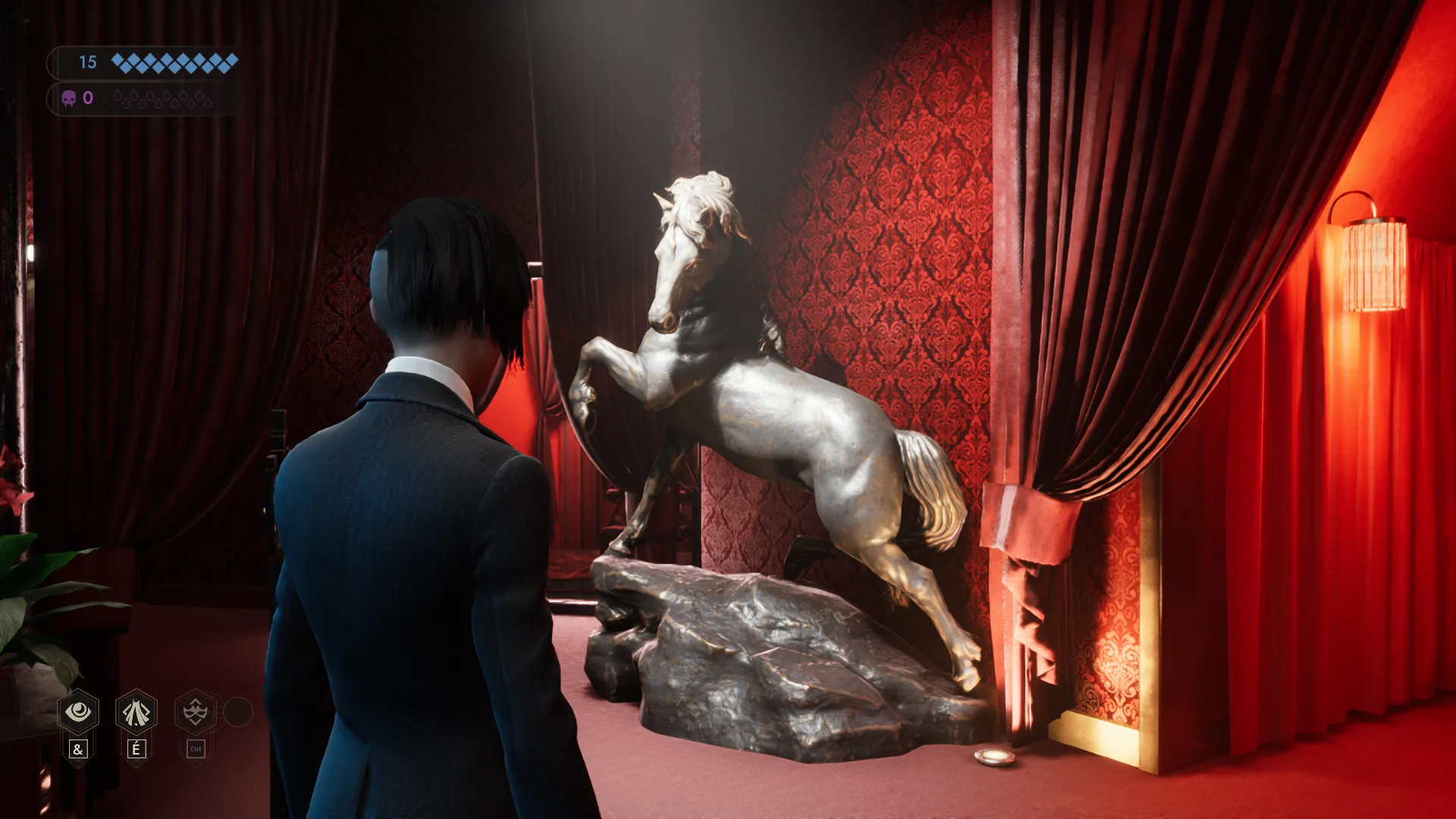 L'image est une capture d'écran du jeu vidéo Vampire: The Masquerade – Swansong. On y voit le personnage joueur de dos, debout dans une pièce tapissée de velour rouge. Des tentures de la même couleur ouvre sur différents espaces attenants (couloirs, alcoves). Face au personnage joueur, contre le mur entre deux tentures, se dresse une imposante sculpture en bronze représentant un cheval.